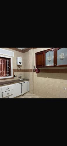 a kitchen with wooden cabinets and a microwave at Mohamed house in Tangier