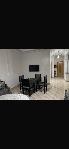 a living room with a table and black chairs at Mohamed house in Tangier