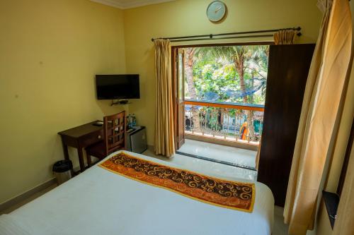 a bedroom with a bed and a large window at Resort Palmeiras Dourado in Cansaulim