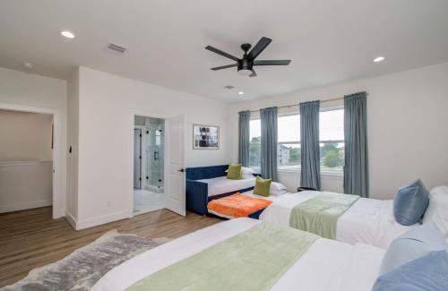 a bedroom with two beds and a ceiling fan at HTX Modern Retreat with Rooftop Cinema in Houston