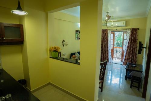 a living room with yellow walls and a dining room at Resort Palmeiras Dourado in Cansaulim