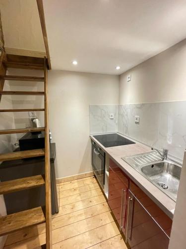 une cuisine avec un évier et un plan de travail dans l'établissement Studio cosy au cœur de Fougères, à Fougères