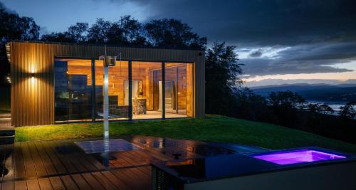a glass house with a hot tub in the yard at Gleddoch Golf & Spa Resort in Langbank