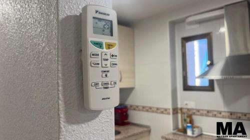 a remote control on the wall of a kitchen at Maysan Apartamento in Benidorm