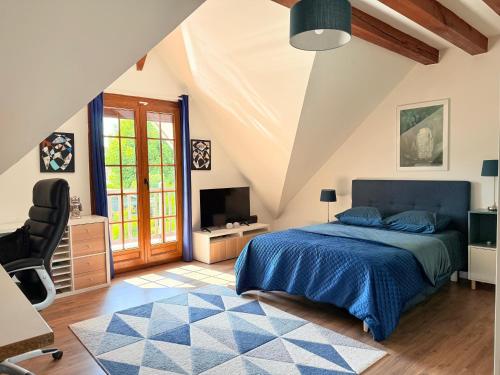 a bedroom with a bed and a desk and a tv at VILLA XXL - SPA & Cuisine d'été in Viarmes