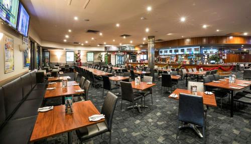 a dining room with wooden tables and chairs at Nightcap at Playford Tavern in Elizabeth