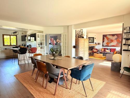 a dining room and living room with a table and chairs at VILLA XXL - SPA & Cuisine d'été in Viarmes