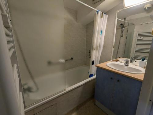 une salle de bain avec une baignoire, un lavabo et une douche dans l'établissement duplex 60m2 dos au port de rochefort, à Rochefort