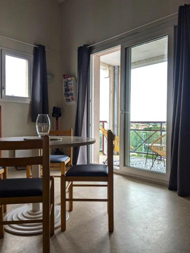 une salle à manger avec une table et des chaises et une fenêtre dans l'établissement duplex 60m2 dos au port de rochefort, à Rochefort