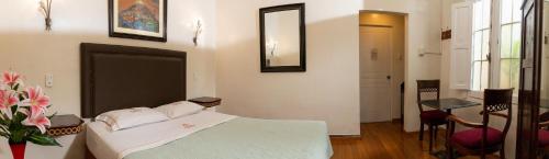 a bedroom with a bed and a table and a mirror at Hospedaje Santa Rosa- Centro Histórico in Lima