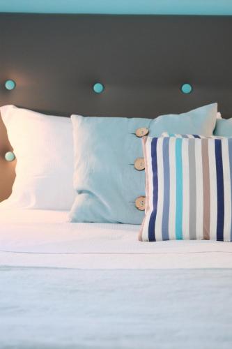 a bed with white sheets and pillows at Pharus Miseni Suites and rooms in Bacoli