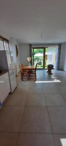 un grand salon avec une table et un banc dans l'établissement Appartement avec jardin, au Bourg-dʼOisans