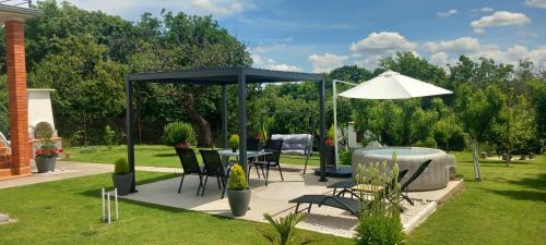 a gazebo with a table and chairs in a garden at Kuća za odmor Milan in Šarengrad