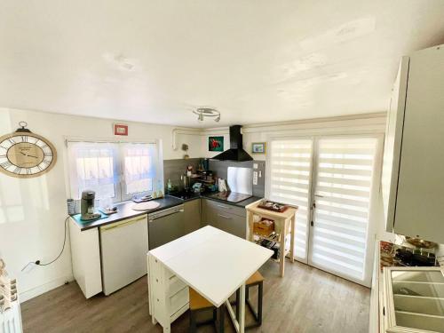 une cuisine avec une table et un comptoir dans l'établissement Les cigales les pieds dans l'eau, à Valras-Plage