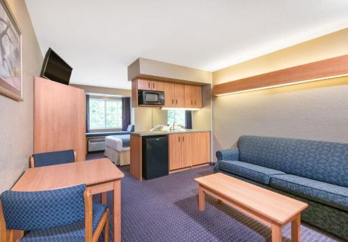 a small living room with a couch and a kitchen at Microtel Inn & Suites by Wyndham Hazelton/Bruceton Mills in Hazelton