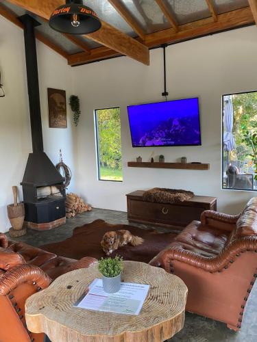 a living room with leather furniture and a flat screen tv at Cabanas Grande Passo in Quatro Barras