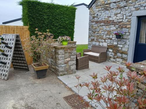a patio with two benches and a stone wall at Le charme des Pierres et wellness in Ohey