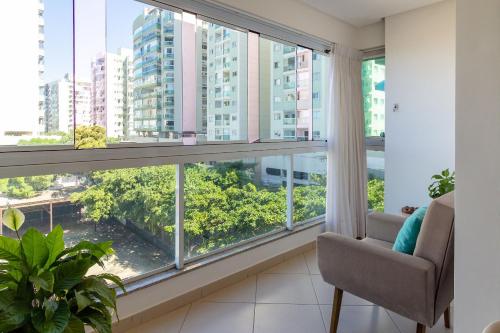 a living room with a large window and a chair at 2Q Casal • Suíte c/ AC • Vista • 2º Andar • NOMDS in Itaparica
