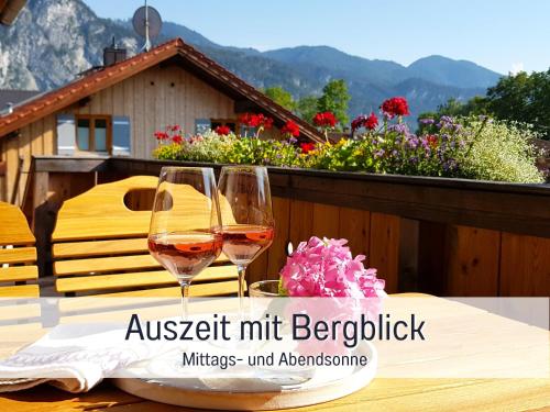 two glasses of wine sitting on a table at Ferienhaus Inntal - ruhig schlafen, zentral starten & wandern bis zum Gipfelglück in Kiefersfelden