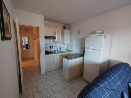 une cuisine avec des armoires blanches et un réfrigérateur blanc dans l'établissement Appartement à 2KM de la plage, à Fréjus