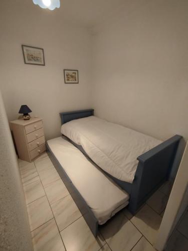 une petite chambre avec un lit et une table de chevet dans l'établissement Appartement à 2KM de la plage, à Fréjus
