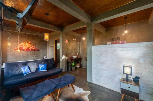 a living room with a blue couch and a brick wall at Recanto Lira 1 e 3 in Monte Verde