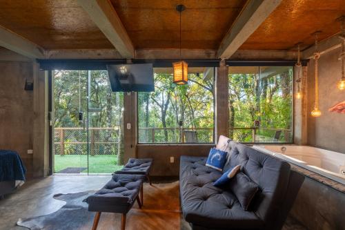 a living room with a couch and a tub at Recanto Lira 1 e 3 in Monte Verde