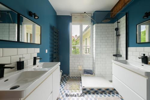 La salle de bains est pourvue de 2 lavabos et de murs bleus. dans l'établissement Latignaciens Chariot d'Or - Maison - 7min DisneyLand, à Lagny-sur-Marne