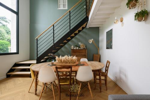 une salle à manger avec une table et des chaises et un escalier dans l'établissement Latignaciens Chariot d'Or - Maison - 7min DisneyLand, à Lagny-sur-Marne