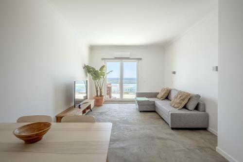 a living room with a couch and a table at Ericeira Bay in Ericeira