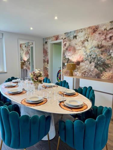 une salle à manger avec une table et des chaises bleues dans l'établissement Gîte le Faune et Flor', au coeur de la nature, à Granges-Aumontzey