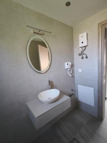a bathroom with a white sink and a mirror at Irina's Apartment 6 in Psakoudia