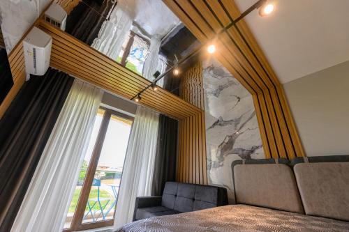 a bedroom with a bed and a large window at Azur Properties ap51 in Shkorpilovtsi