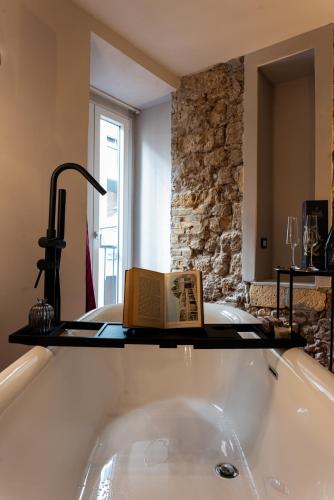 a book sitting on top of a bath tub at Chiave di Volta luxury suite e rooms in Palermo