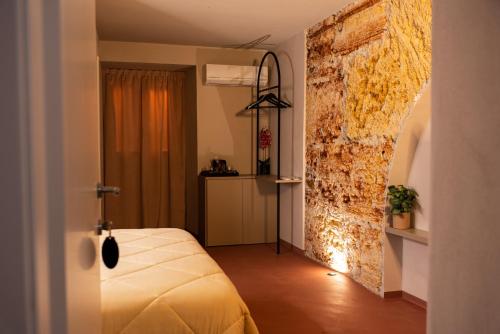 a bedroom with a bed and a brick wall at Chiave di Volta luxury suite e rooms in Palermo