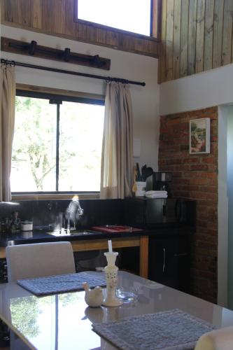 a kitchen with a table and a window at Cabanas Grande Passo in Quatro Barras