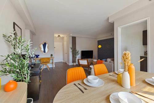 a dining room and living room with a table and orange chairs at CASA Arlington Suite with Top-Tier Amenities & Parking in Arlington