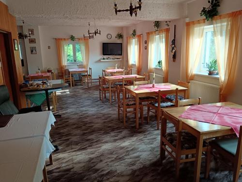 a restaurant with tables and chairs in a room at Horsky hotel Sport in Josefuv dul