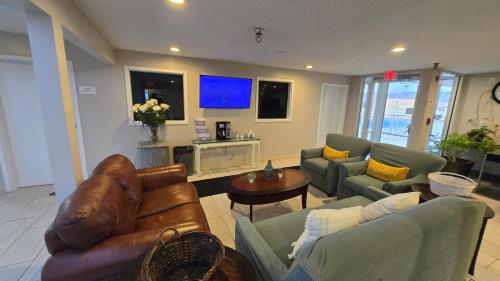 a living room with two couches and a tv at Copley Inn & Suites By OYO Akron OH in Akron