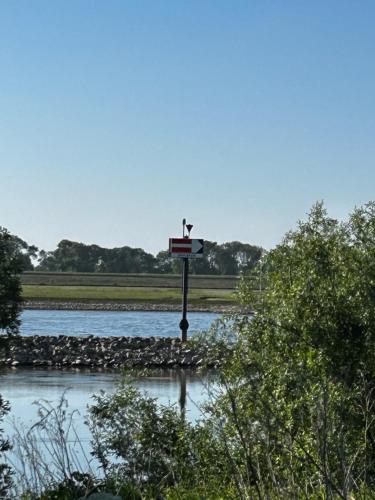a cross on a pole in the middle of a river at Uilehoeve aan de Waal in Zennewijnen