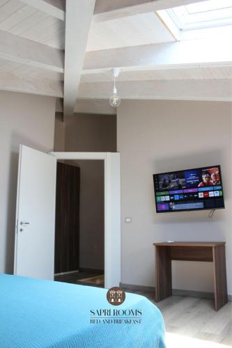 a room with a bed and a tv on the wall at Sapri Rooms in Lamezia Terme