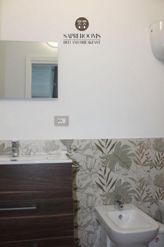 a bathroom with a sink and a mirror at Sapri Rooms in Lamezia Terme