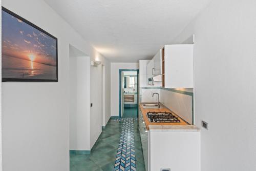 a kitchen with white cabinets and a stove top oven at B&B Residence Eco Del Mare in Palinuro