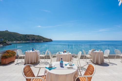 a patio with tables and chairs and the ocean at B&B Residence Eco Del Mare in Palinuro