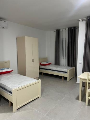 a room with two beds and a cabinet in it at Vila Zyle in Velipojë
