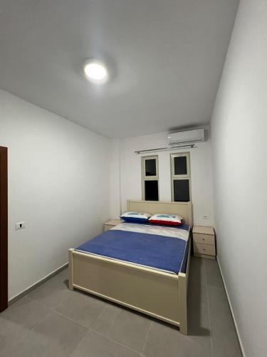a bedroom with a bed in a white room at Vila Zyle in Velipojë