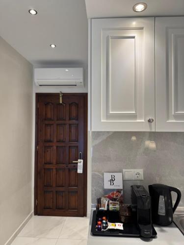 a kitchen with a door and a coffee maker on a counter at Amaryllis Luxury Rooms in Platamonas