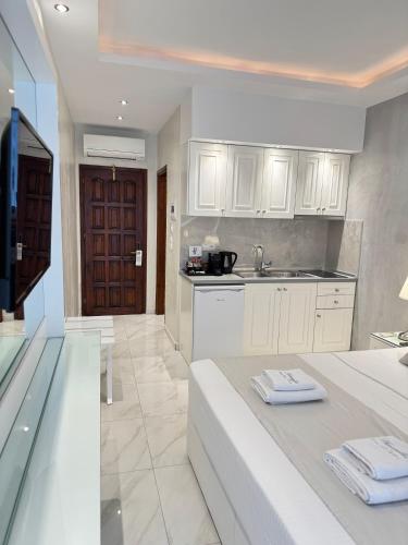 a kitchen with white cabinets and a sink at Amaryllis Luxury Rooms in Platamonas