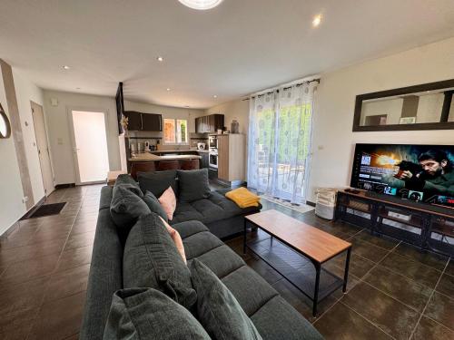 un salon avec un canapé et une table dans l'établissement L'Évasion Vendéenne - Spacieuse Maison, à Aubigny