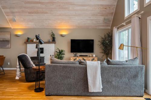 a living room with a couch and a tv at Serenity Shores 5BD Hot Tub Fishing Hiking in Traverse City